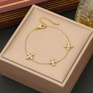 Elegant gold flower bracelet with clear zircon clovers on a beige jewelry cushion