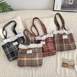 Close-up of vintage plaid wool tote bags featuring delicate white lace trim details
