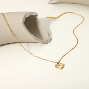 Close-up of 18K gold plated heart pendant with clear zircons on minimalist grey stone