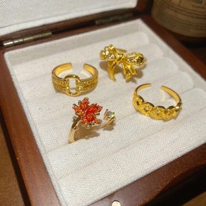 Detail of four 18k gold plated adjustable rings with maple leaf and bowknot zircons