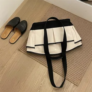 Detail of canvas tote bag with contrast piping and pleated design on a woven mat