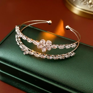 Détail d'un bracelet argenté double couche avec fleur en zircon sur boîte à bijoux verte