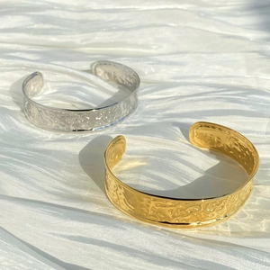 Polished stainless steel open bangles in gold and silver with hammered texture on satin