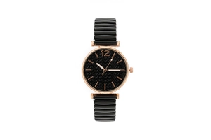 Dettaglio della cassa in oro rosa con quadrante nero e cinturino elastico da donna