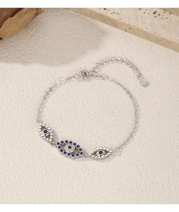 Gros plan du bracelet œil protecteur argenté avec pierres bleues et blanches