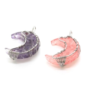Detail of wire-wrapped crescent moon pendants with purple and pink natural crystal chips