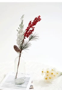 Macro detail of artificial Christmas branch with pine cones, red berries and snow coating