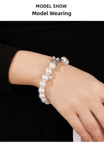 Elegant 925 silver pearl bracelet with sparkling zircon butterfly charms on a model's wrist