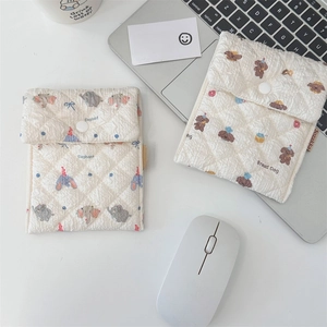 Close-up of quilted storage pouches with cute elephant and dog patterns on a desk