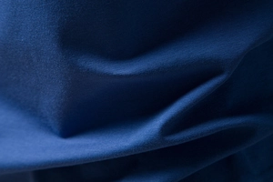 Detailed close-up of dark blue cotton fabric showing fine knit texture and soft fibers