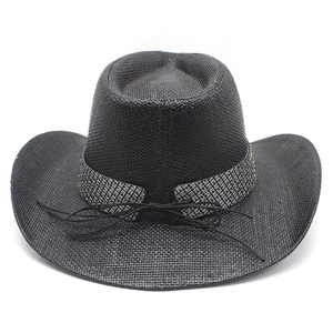 Detail of black straw cowboy hat featuring wide brim and textured geometric hatband