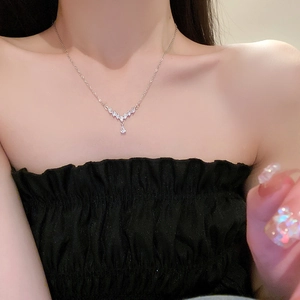 Close-up of V-shaped silver necklace with water drop zircon pendant worn by a model