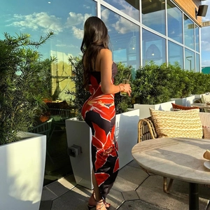 Détail d'une robe longue d'été ajustée avec imprimé floral rouge sur fond noir élégant