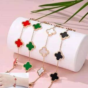 Detail of four-leaf clover bracelets in red, green, black and white with rose gold finish