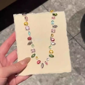 Detail view of multi-color crystal necklace with various gem cuts on a display card