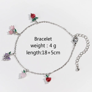Detail of silver chain bracelet with colorful grape cherry and strawberry charms