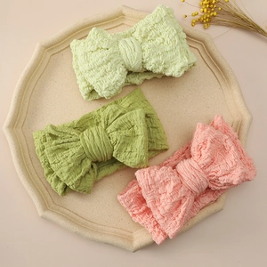 Detailed view of large oversized bow headbands in three soft colors with crinkle texture