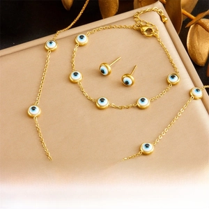 Detail of gold evil eye jewelry set with necklace bracelet and stud earrings