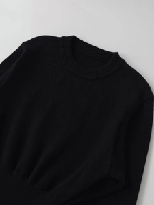 Close-up of the fine knit texture and classic ribbed crew neck on this black sweater