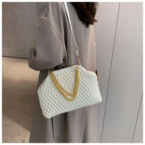 Detail of white quilted handbag featuring multi-layer gold chain straps and soft texture