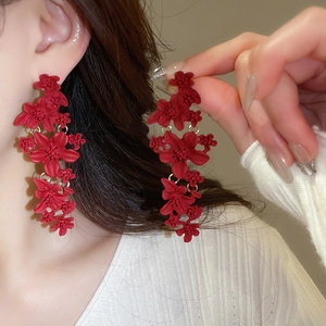 Close-up of elegant red matte floral drop earrings with a retro Chinese style aesthetic