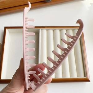 Detailed view of pink matte banana hair clip showing internal teeth and sturdy grip