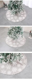 Détail du tapis de sapin de Noël gris en peluche avec motifs flocons de neige