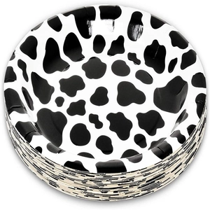 Stack of round paper plates with black and white cow print for farm theme party decoration