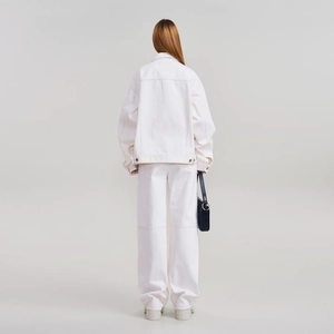 Détail d'une veste en denim blanc et d'un pantalon large montrant la coupe du dos moderne