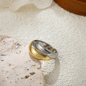 Detailed view of two-tone gold and silver layered ring on a textured stone base