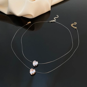 Set of two minimalist transparent fishing line necklaces with heart-shaped zircon pendants
