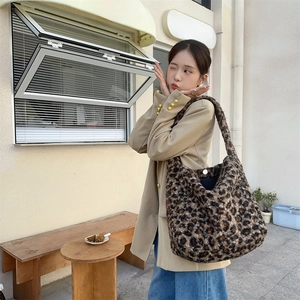 Detailed close-up of leopard print faux fur tote bag with wide strap and metal buckle