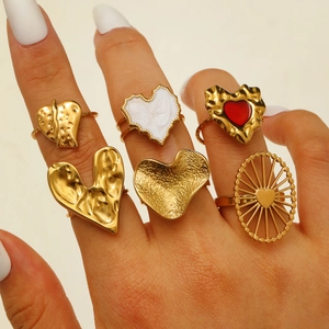 Close-up of gold heart rings set with lava texture and colorful enamel details