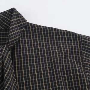 Detail view of the classic plaid collar and shoulder seam on a checkered long sleeve shirt