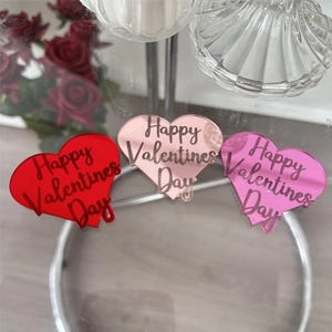 Close-up of heart-shaped acrylic cupcake toppers in red, rose gold and pink mirror finishes