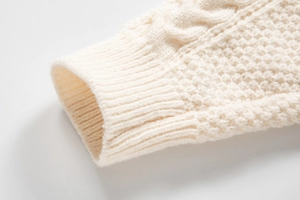 Dettaglio dei polsini a coste e trama a treccia del maglione girocollo uomo bianco crema
