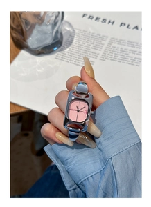 Close-up of a silver square watch with pink dial and chic chain link bracelet on wrist