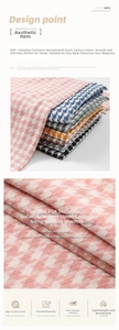 Detailed close-up of soft houndstooth cashmere-like fabric and warm tassel texture