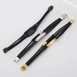 Close-up of multilayer leather bracelets with black, gold, and silver stainless steel beads