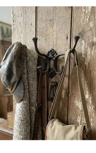 Detail of vintage cast iron coat hook featuring rustic industrial multi-prong design