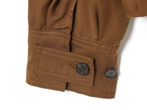 Close-up of brown twill jacket cuff with two black buttons and premium stitching