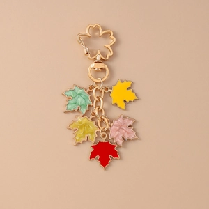 Detailed view of colorful enamel maple leaf pendants on a golden flower keychain