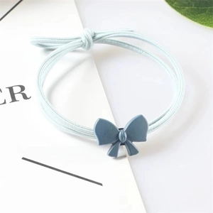 Detail of light blue bow hair tie with triple-strand elastic cord on aesthetic card