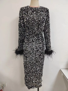 Détail de la robe de soirée à paillettes noires avec bordure en plumes d'autruche chic