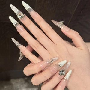 Handmade stiletto press-on nails with silver glitter, nude gradient, and 3D rhinestones