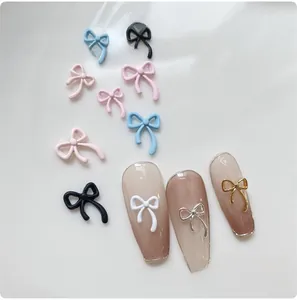 Macro detail of 3D alloy bow nail art charms in multiple colors for DIY manicure design