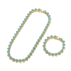 Detail view of gold Cuban link chain set with blue heart-shaped pavé crystals