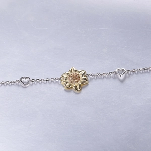 Detailed view of S925 silver bracelet featuring golden sunflower and hollow heart charms