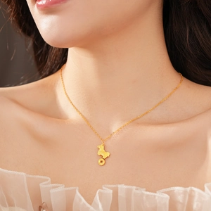 Close-up of a gold-plated horse and coin pendant necklace on a female model neck