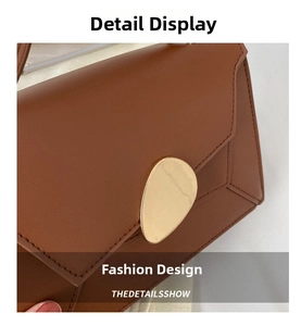 Close-up of caramel brown leather handbag with fine stitching and irregular gold metal buckle